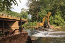 Construction equipment working to remove the Weston Mill dam on New Jersey's Raritan River.